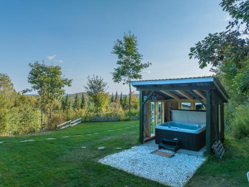 a gazebo with a hot tub in the grass at Refuge Exitchalets Spa & View in Sainte-Lucie-de-Doncaster