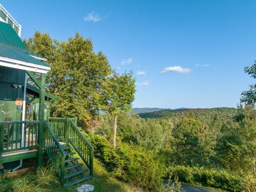 a porch of a house with a view of the mountains at Refuge Exitchalets Spa & View in Sainte-Lucie-de-Doncaster