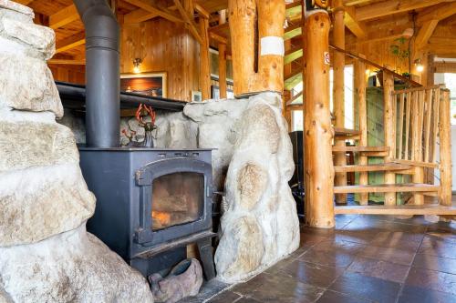 a large stone fireplace in a wooden room at Refuge Exitchalets Spa & View in Sainte-Lucie-de-Doncaster