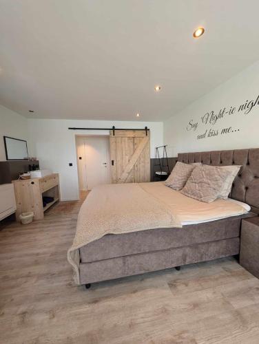 a bedroom with a large bed with a sign on the wall at Rêveries in Roeselare