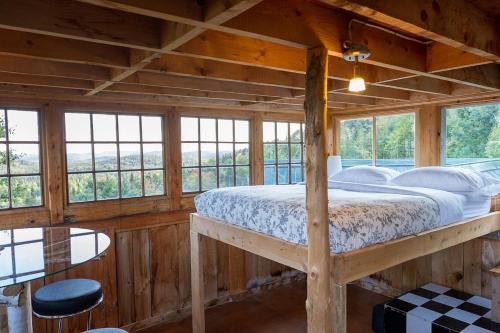 a bedroom in a log cabin with a bed and a table at Refuge Exitchalets Spa & View in Sainte-Lucie-de-Doncaster