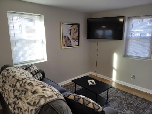 a living room with a couch and a flat screen tv at Davenport Dwelling Unit 9 Midtown 3BD in Omaha