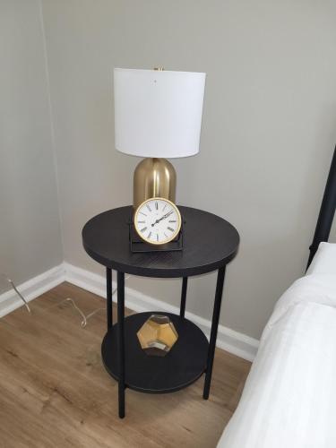 a table with a clock on it next to a bed at Davenport Dwelling Unit 9 Midtown 3BD in Omaha
