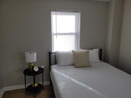 a bedroom with a white bed with a window at Davenport Dwelling Unit 9 Midtown 3BD in Omaha