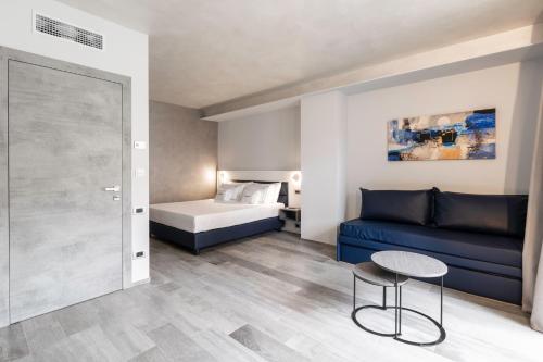 a living room with a blue couch and a bed at CORSO49 Boutique Rooms in Civitanova Marche