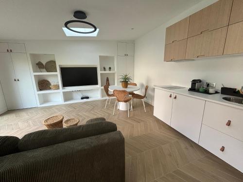 une cuisine et un salon avec un canapé et une table dans l'établissement Charmante Maison 2 pièces proche centre-ville, à Bagneux