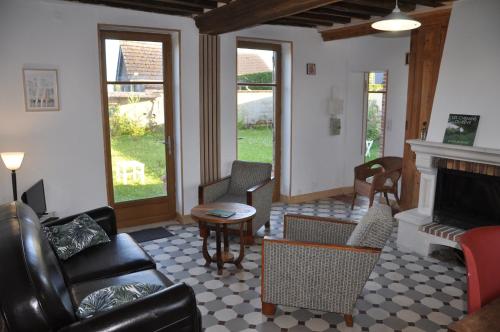 a living room with furniture and a fireplace at Au Château des Ifs in La Haye-de-Routot
