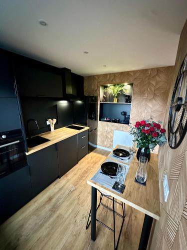 une cuisine avec une table avec un vase de fleurs dessus dans l'établissement Le Temple - Love Room au coeur des remparts, à Clermont-Ferrand