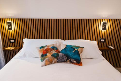 a white bed with two pillows on it at Humboldt Luxury Rooms Taormina in Taormina