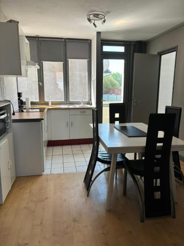 une cuisine et une salle à manger avec une table et des chaises dans l'établissement La Sarcelle, à Fort-Mahon-Plage