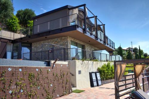 a house with a balcony on top of it at Sky View Garda Lake by Hotel Galvani in Torri del Benaco