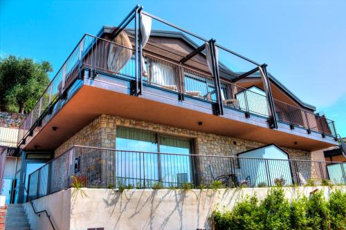 a building with a balcony on top of it at Sky View Garda Lake by Hotel Galvani in Torri del Benaco