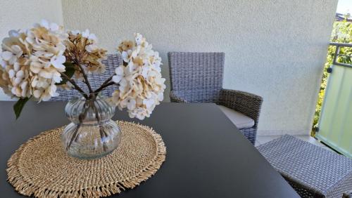 a vase with white flowers sitting on a table at Ferienwohnung Ingolstadt Eichstätt Altmühltal in Eitensheim