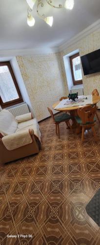 a living room with a bed and a table and a couch at Casa Rosa in Pescocostanzo