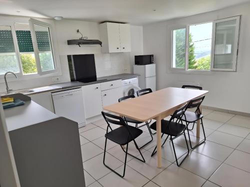 Il comprend une cuisine avec une table et des chaises en bois. dans l'établissement Maison Harandi Etxea, à Bardos