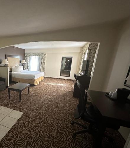 a large hotel room with a bed and a television at Country Inn & Suites by Radisson, Murrells Inlet, SC in Myrtle Beach