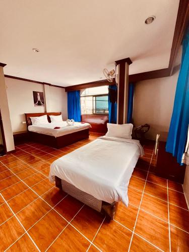a bedroom with two beds in a room with blue curtains at Centre Point Patong in Patong Beach
