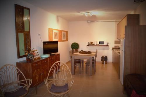 a living room with a kitchen and a table with chairs at Casa do Manego in Quadrazais