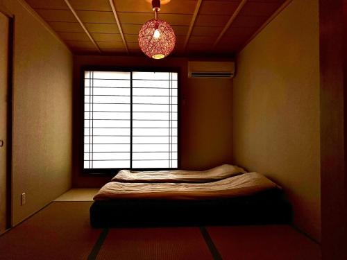 a room with a bed in front of a window at 木木町屋 mumu Machiya Kyoto in Kyoto