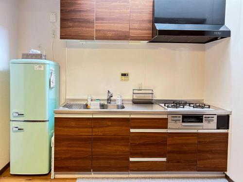 a kitchen with a refrigerator and a sink at 木木町屋 mumu Machiya Kyoto in Kyoto