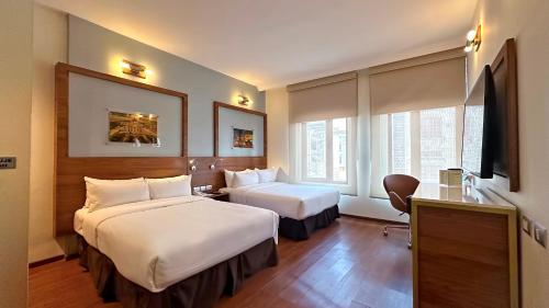 a hotel room with two beds and a television at Hotel Ritz Ciudad de México in Mexico City
