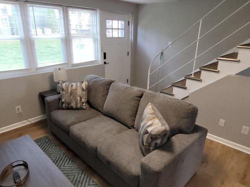 a living room with a couch and a staircase at Davenport Dwellings 10- By UNMC in Omaha