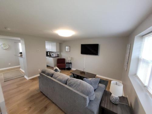 a living room with a couch and a flat screen tv at Davenport Dwellings 10- By UNMC in Omaha