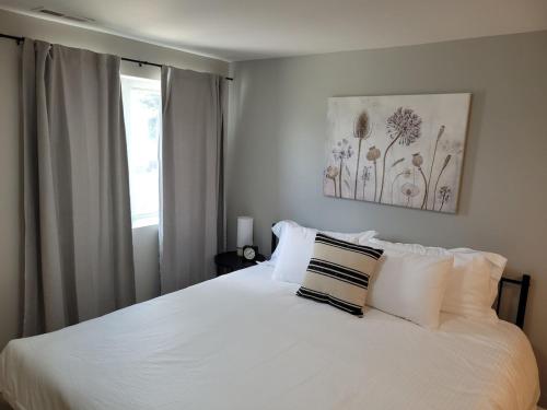 a bedroom with a white bed with white pillows at Davenport Dwellings 10- By UNMC in Omaha