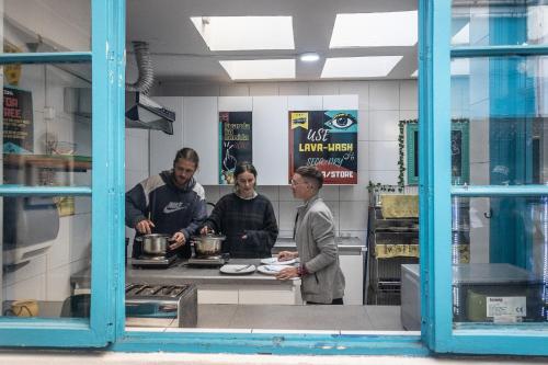 a group of people standing in a kitchen at Hostal Providencia in Santiago