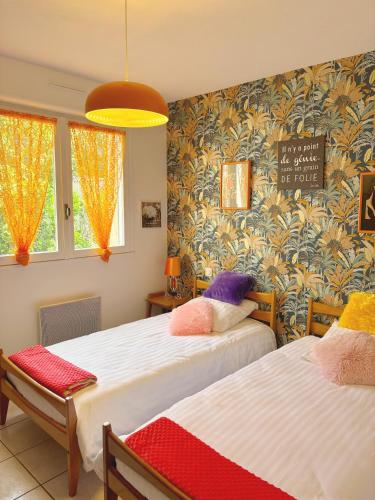 - une chambre avec 2 lits et un panneau mural dans l'établissement Appartement hypercentre avec parking, à Albi