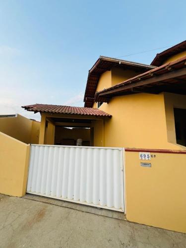 a white fence in front of a house at Casa Amarela in Penha
