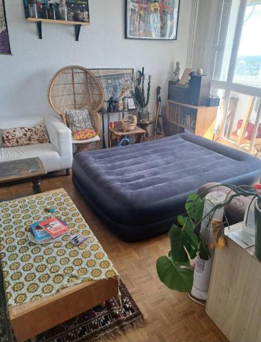 un salon avec un grand lit bleu dedans dans l'établissement Appartement avec vue panoramique, à Longjumeau