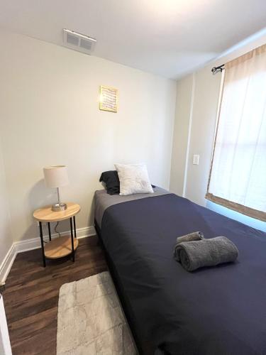 a bedroom with a bed and a table with a lamp at Chic City Escape in Berwyn