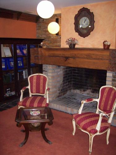 a living room with two chairs and a fireplace at La Rectoral in Taramundi