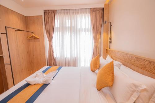a bedroom with a large white bed with a window at Hotel Vistara in Kathmandu