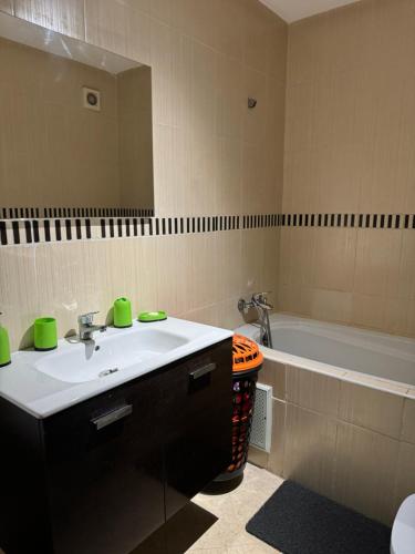 a bathroom with a sink and a bath tub at Chez Mamie Kenza in Mohammedia