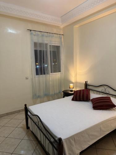 a bedroom with a large bed with a window at Chez Mamie Kenza in Mohammedia