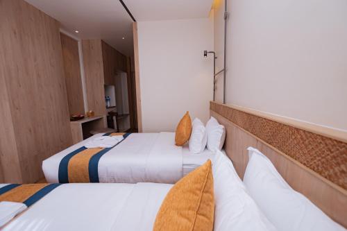 a hotel room with two beds with white sheets at Hotel Vistara in Kathmandu