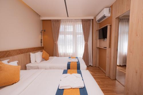 a hotel room with two beds and a television at Hotel Vistara in Kathmandu