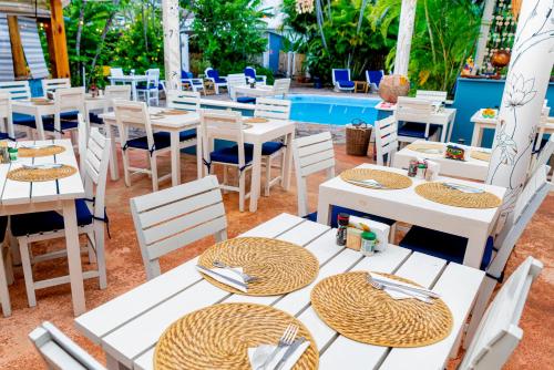 a restaurant with white tables and chairs next to a pool at Le BDM PLAYITA in Las Galeras