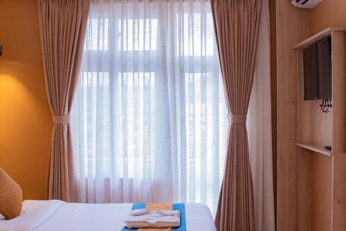 a bedroom with a bed and a window with curtains at Hotel Vistara in Kathmandu
