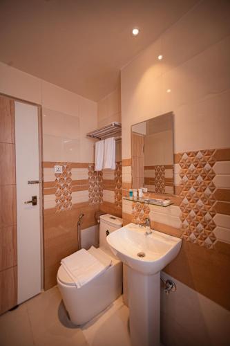 a bathroom with a white toilet and a sink at Hotel Vistara in Kathmandu