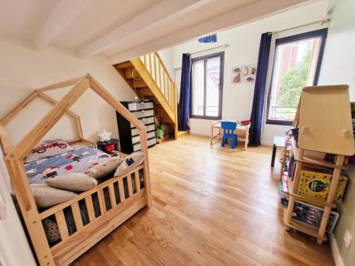 - une chambre avec un lit dans un dortoir doté de parquet dans l'établissement belle Maison familiale, jardin, à LʼÎle-Saint-Denis