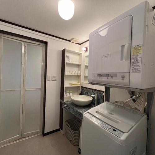 a small kitchen with a sink and a microwave at 木木町屋 mumu Machiya Kyoto in Kyoto