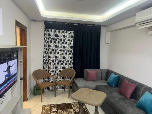 a living room with a couch and a tv at برتو جولف مارينا in El Alamein