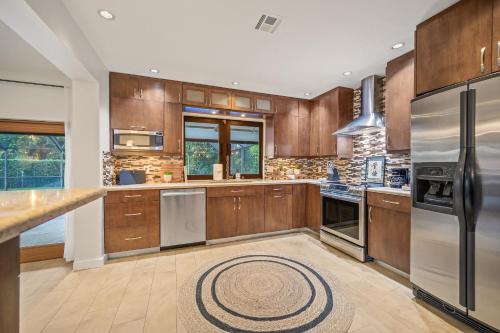 a kitchen with wooden cabinets and stainless steel appliances at Family Beach Home With Home Theater & Heated Pool! in Hollywood