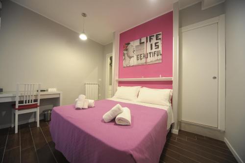 Un dormitorio con una cama rosa con toallas. en Bbrothershouse, en Roma