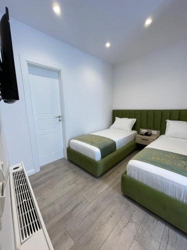 a hotel room with two beds and a television at Reign Hotel in Vorë
