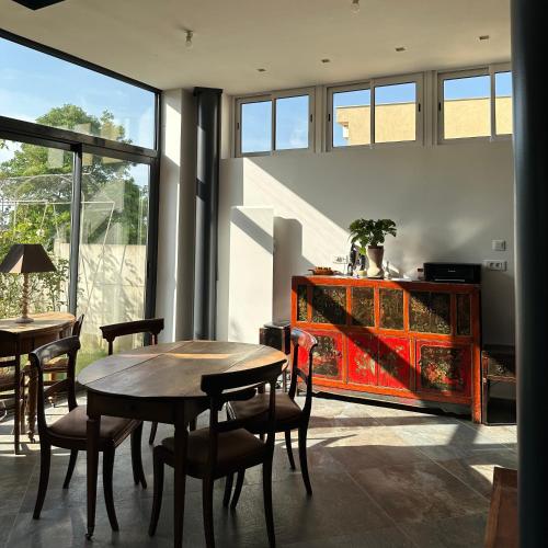une salle à manger avec deux tables et une armoire rouge dans l'établissement La Maison Du Coteau, à Cachan