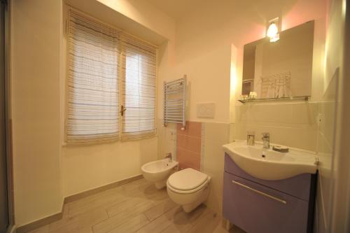 ein Badezimmer mit einem weißen WC und einem Waschbecken in der Unterkunft Bbrothershouse in Rom